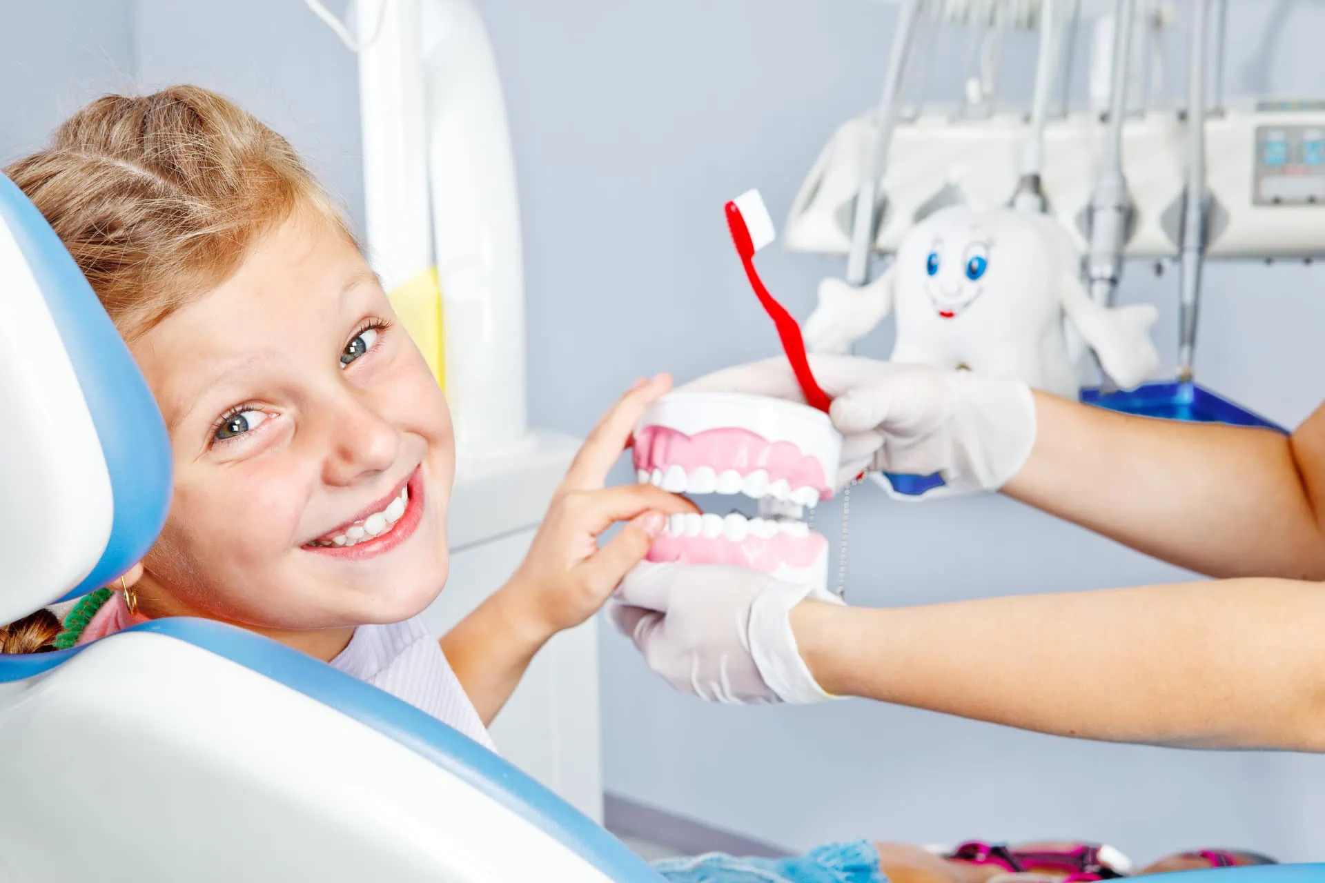 Parent and child brushing teeth together and smiling